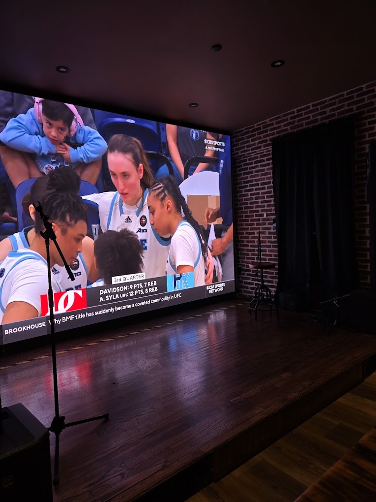 Fans watching sports on jumbo screens at The Husky Den